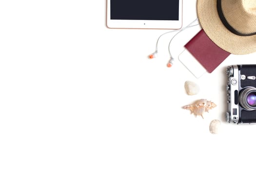 Travel accessories set top view on white background : passport, camera, straw hat, digital tablet , headphones, shells . Copy space.