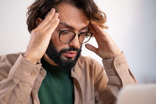 Worried man suffering from headache at work - Entrepreneur thinking about problems and project deadline feeling exhausted. High quality photo