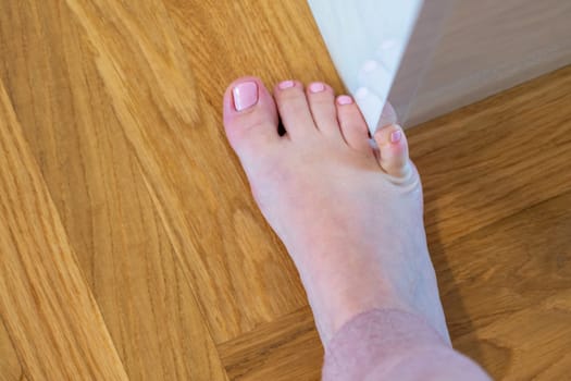 Woman hit furniture with the little toe. Accident at home. Injury of foot little finger