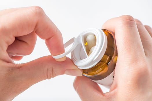 Antidepressants, taking pills for depression and disorders of the central nervous system. A woman's hand opens a bottle of antidepressants close-up on a white background