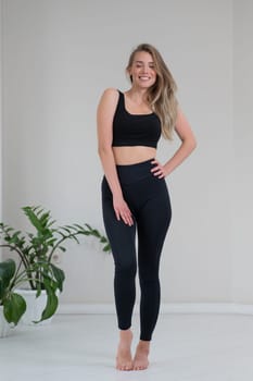 Full length portrait of a beautiful caucasian woman in black sportswear