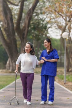 Healthcare nurse, physical therapy with elderly woman at outdoor. Nurse holding hand and help elderly woman walking.