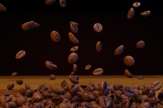 Flying roasted coffee beans drop in the air ,Roasted coffee beans on wooden background. ,isolated on black background, 3d rendering.