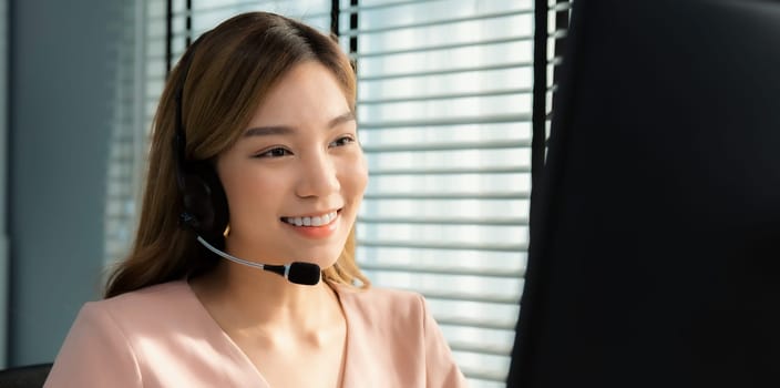 Competent female operator working on computer and while talking with clients. Concept relevant to both call centers and customer service offices.