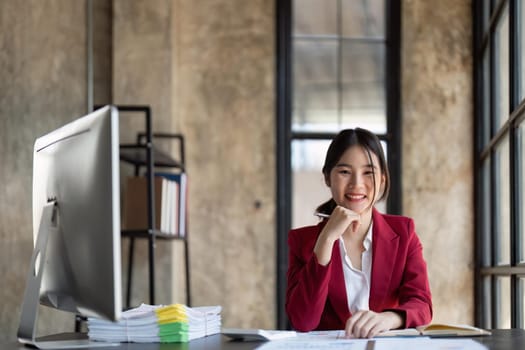 Portrait of a attractive businesswoman sitting at the table in office and looking at camera.