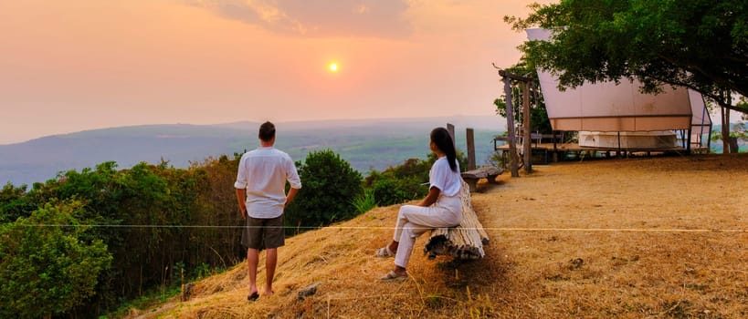 A couple of men and women watching the sunset at a mountain camping in Phitsanulok Thailand. luxury glamping