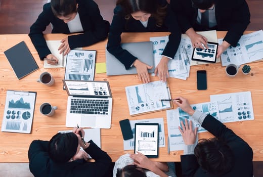 Top-view business team of financial data analysis meeting with business intelligence, report paper and dashboard on laptop for marketing strategy. Business people working together in office of harmony