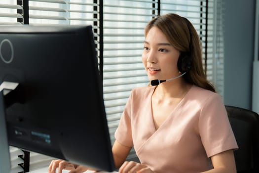 Competent female operator working on computer and while talking with clients. Concept relevant to both call centers and customer service offices.