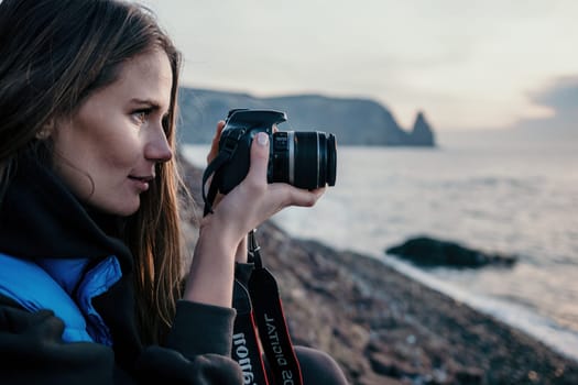 Woman travel sea. Happy tourist taking picture outdoors for memories. Woman traveler looks at the edge of the cliff on the sea bay of mountains, sharing travel adventure journey.