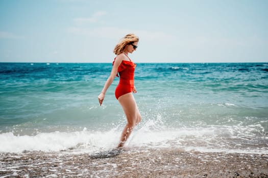 Pretty young blonde woman walking on the beach in summer, having fun, walks carefree on the seaside . Portrait beautiful young woman relax smile around beach sea ocean in holiday vacation travel trip.