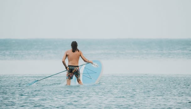 Sea woman and man on sup. Silhouette of happy young woman and man, surfing on SUP board, confident paddling through water surface. Idyllic sunset. Active lifestyle at sea or river