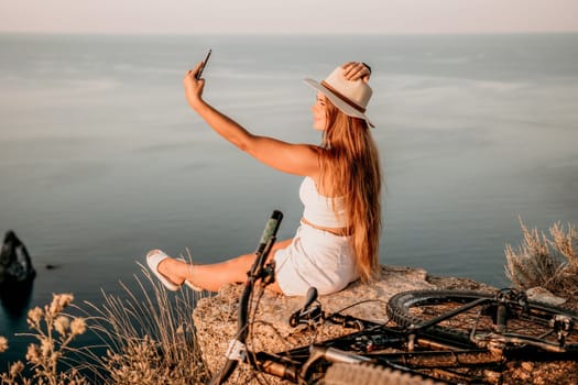 Woman travel sea. Young Happy woman in a long red dress posing on a beach near the sea on background of volcanic rocks, like in Iceland, sharing travel adventure journey