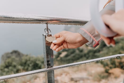 Metal padlocks covered with rust, hanging by the lovers on iron railings on the pier