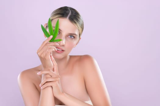 Alluring beautiful woman model portrait holding green leaf as concept for cannabis skincare cosmetic product for perfect skin freshness treatment in isolated pink background.