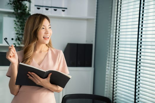 Young competent office lady, intern, secretary holding a log in office room. Concept of various career for office working. Concept of diverse office careers.