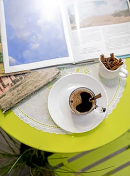 Tourism concept. Cup of coffee and books on a table in a cafe