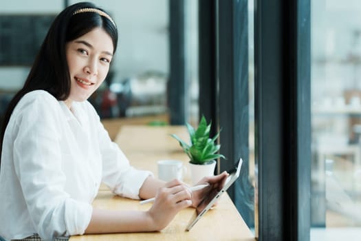 Portrait of a beautiful Asian teenage girl using a tablet computer.