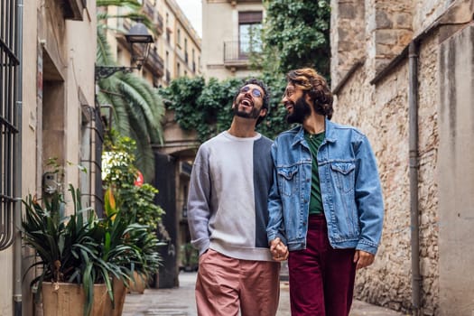 gay male couple walking happy holding hands along a beautiful ancient street decorated with plants, concept of leisure and love between people of the same sex