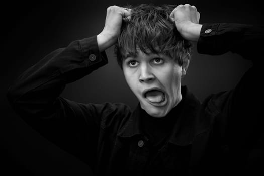 portrait of crazy young man with awesome hairdo grimacing . black and white