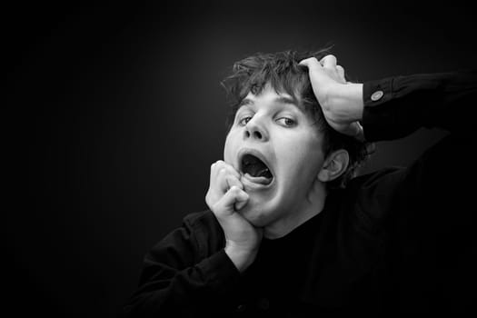 portrait of crazy young man yelling with a violent or desperate face and grimacing . black and white