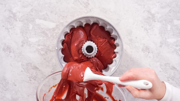Flat lay. Step by step. Pouring cake batter into a bundt cake pan to bake a red velvet bundt cake.