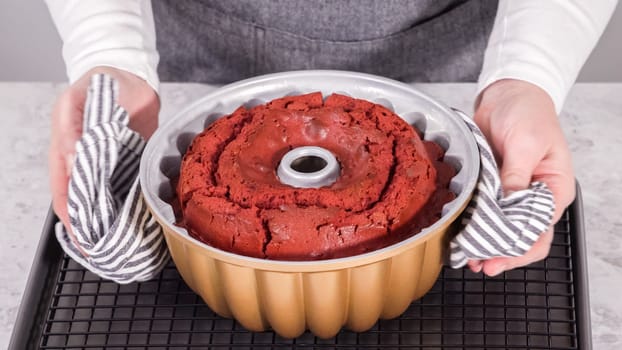 Step by step. Cooling freshly baked red velvet bundt cake on a kitchen drying rack.