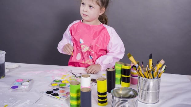 Kids papercraft. Painting empty toilet paper rolls with acrylic paint to create paper bugs.
