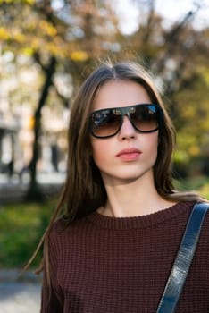 Close up shot of stylish young woman in sunglasses at the street. Beautiful female model.