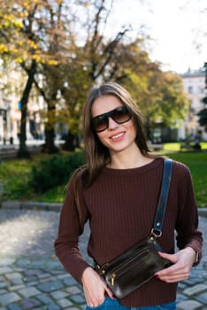 Close up shot of stylish young woman in sunglasses at the street. Beautiful female model.