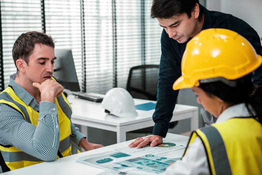 Engineers and competent employer discussing plans and blueprints together with tablet in the office. Concept of team contribution of ideas for engineering project.