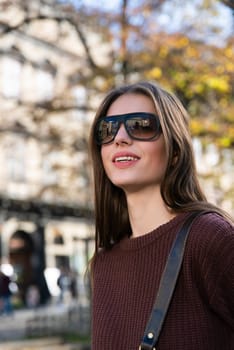 Close up shot of stylish young woman in sunglasses at the street. Beautiful female model.