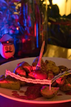 Potato dressed as a policeman in front of a plate with potato wedges shown as a crime scene