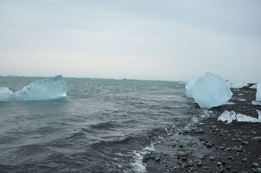 Crystal clear ice chunks at Diamond beach with black sand in Fellsfjara, Jokulsarlon on Iceland