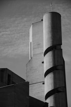 Vertical grayscale shot of a church tower with a spiral staircase