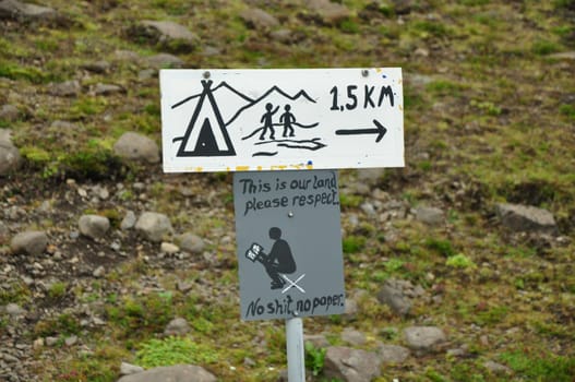 Road sign of camping and warning to not shit or use paper