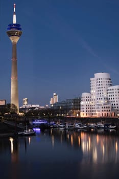 View of Gehry buildings and tv tower at Dusseldorf's media harbor at night