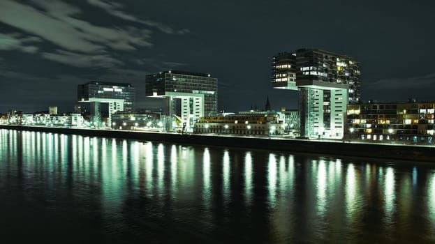 Aerial view of illuminated crane houses by the canal at the Zollhafen in Cologne, Germany at night