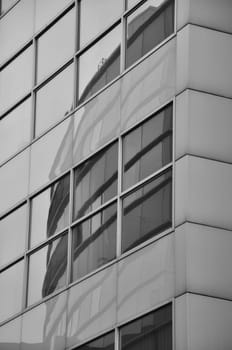 Vertical grayscale shot of buildings reflection in window pane in Media Harbor. Dusseldorf, Germany.