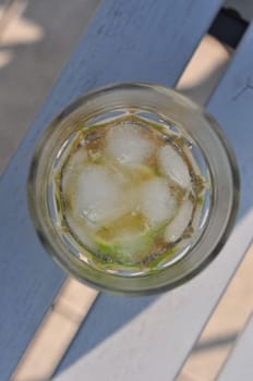 Top view of a fresh, cool mojito cocktail with ice cubes, mint leaves and lemon slices in it