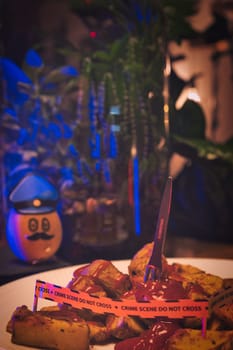 Potato dressed as a policeman in front of a plate with potato wedges shown as a crime scene