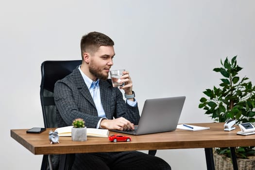 young bearded man sitting at desk work on laptop pc computer