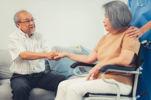 A contented senior couple and their in-home nurse. Elderly female in wheelchair with her young caregiver.