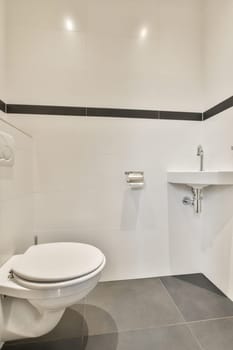 a modern bathroom with black and white tiles on the floor, toilet and sink are visible in this image taken from above