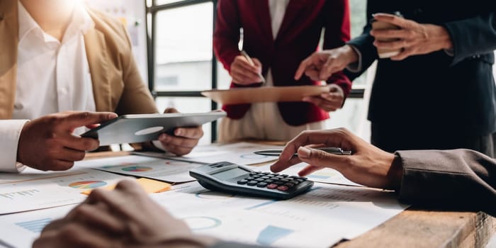 Business People Meeting using laptop computer,calculator,notebook,stock market chart paper for analysis Plans to improve quality next month. Conference Discussion Corporate Concept....