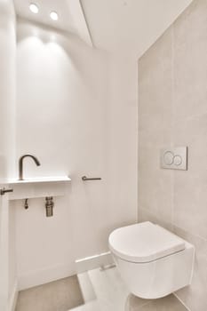 a bathroom with a white toilet and light fixtures on the wall in front of the toilet is illuminated by recessed lighting