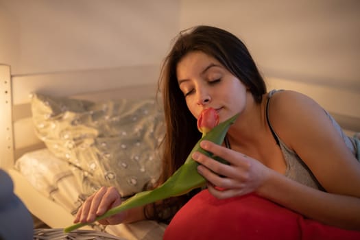 A teenage girl gets intoxicated by the fresh scent of the tulip flower. A nice surprise on the morning of lovers' day from the other half.