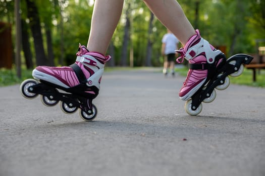 Learning to do tricks on roller skates. A city park suitable for sports. Playing sports outdoors. Active relaxation in nature.