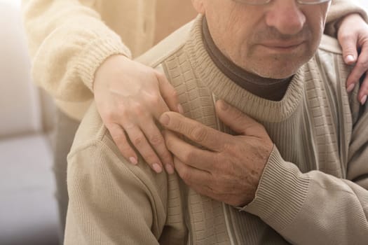 Young woman holding senior man hands, closeup.