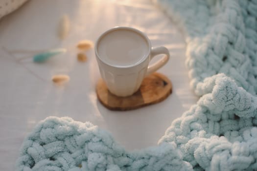 Light cozy bedroom, Coffee cup and gift or book on the bed. Good morning
