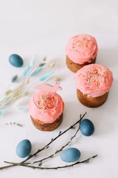 Plate with tasty Easter cake, eggs and willow branches on dark background. High quality photo